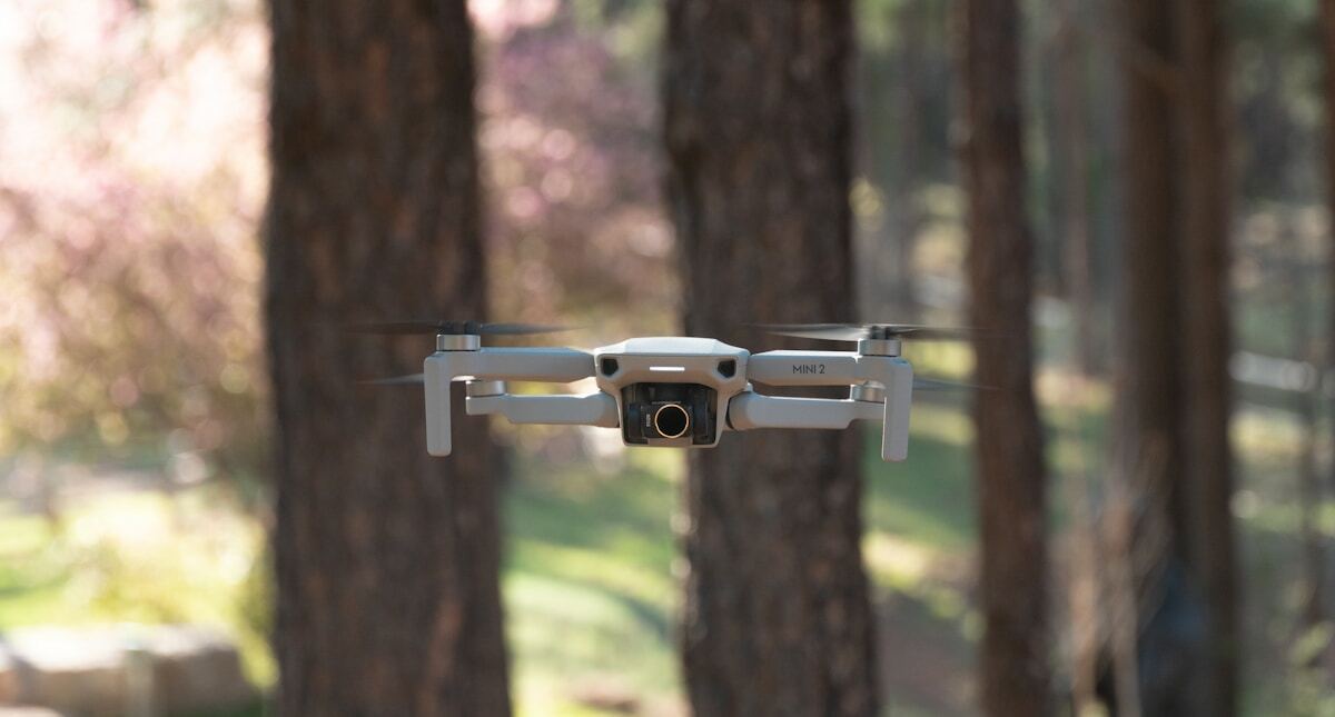 silver and black drone on brown tree trunk