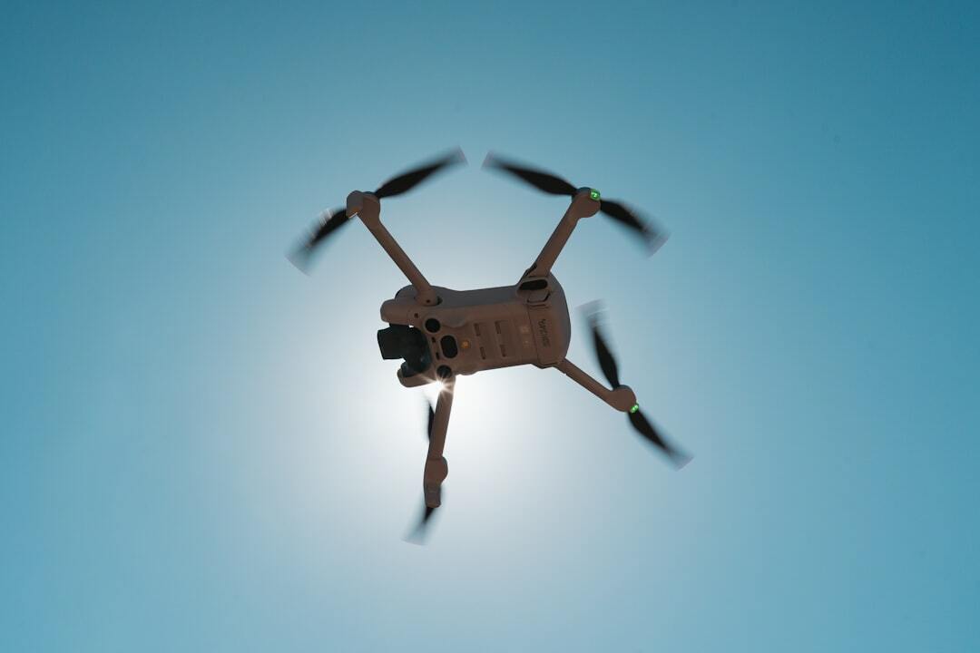 "Drone volant dans un ciel bleu avec logiciel photogrammétrie drone gratuit pour des vols précis."