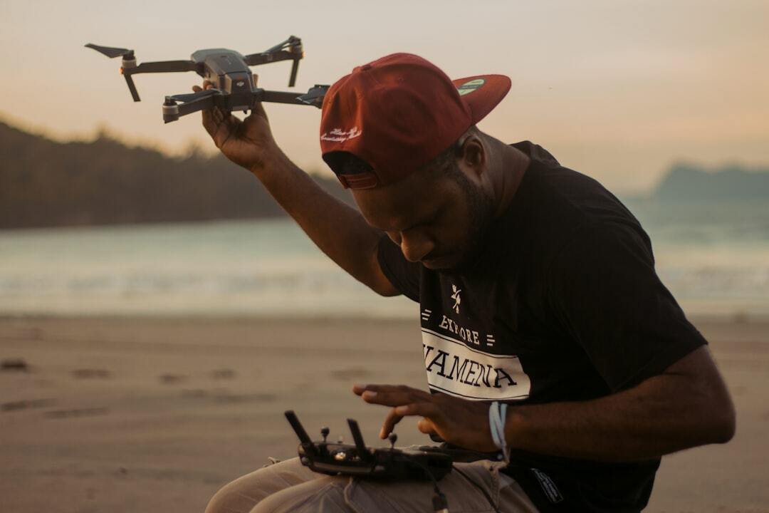 "Homme en t-shirt noir et blanc tenant une canne à pêche, initiation formation drone pour débutant en loisirs nautiques"