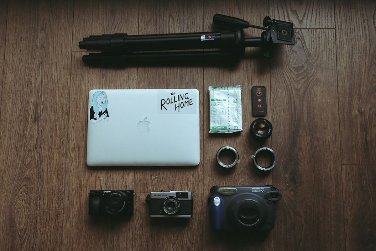 A table with a laptop, camera, and other items on it