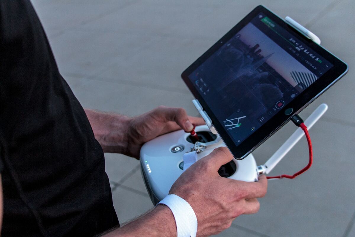Homme utilisant une manette de jeu sur une tablette électronique.