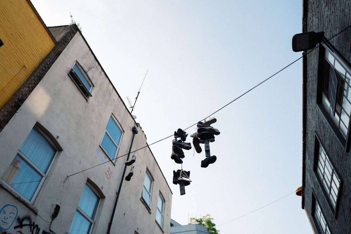 Bâtiments urbains avec chaussures suspendues au-dessus de la rue.