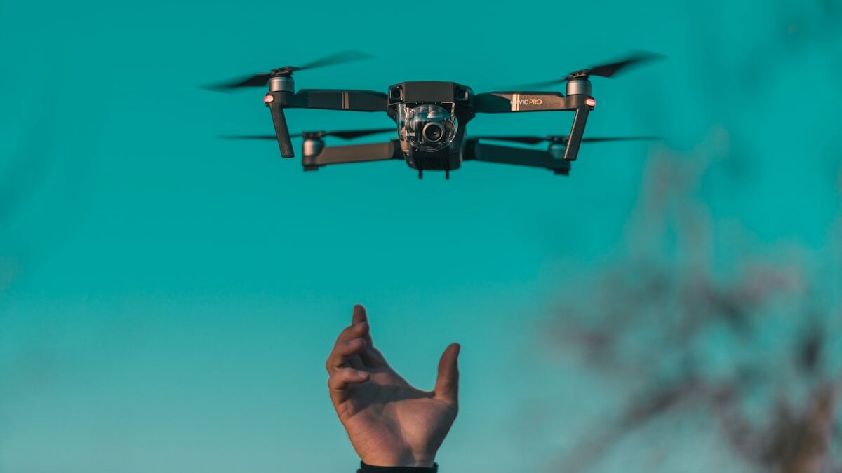 Drone volant dans le ciel bleu avec une main tendue.