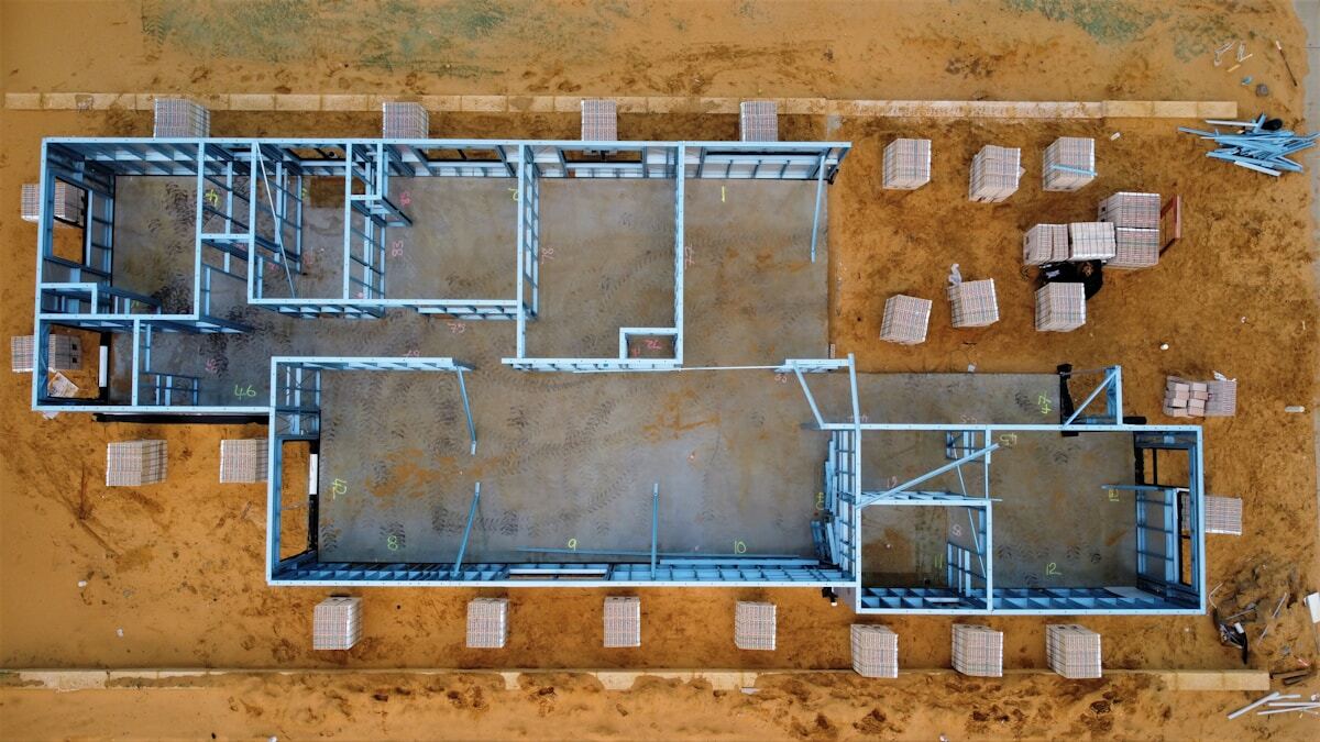 Schéma architectural détaillé d'un bâtiment en construction avec des structures métalliques et des matériaux de construction.